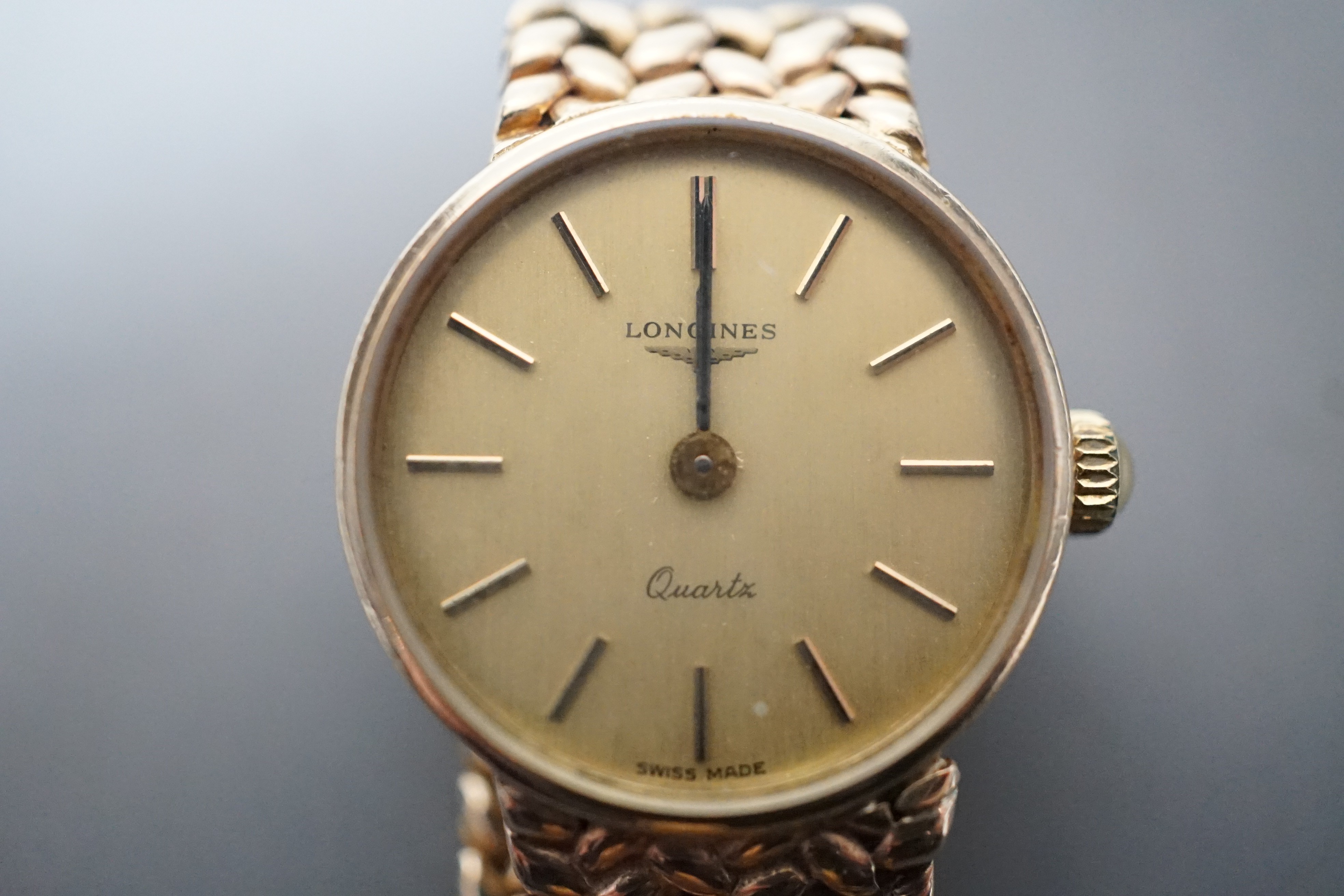 A lady's 9ct gold Longines quartz wrist watch on an inegral 9ct gold bracelet, with Longines box